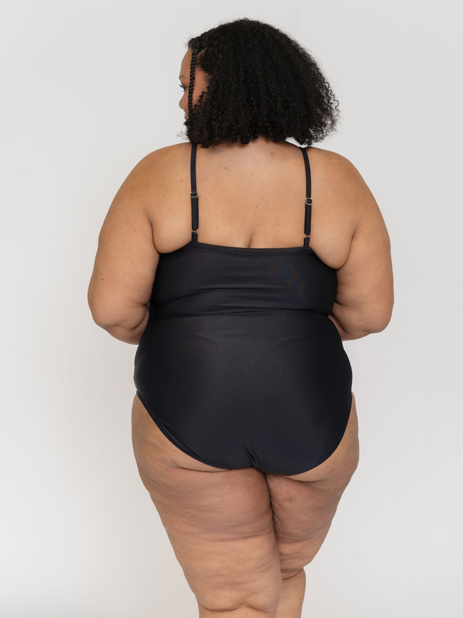 woman wearing a black swimsuit against a white background