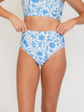 Woman wearing a blue floral bikini on a white background