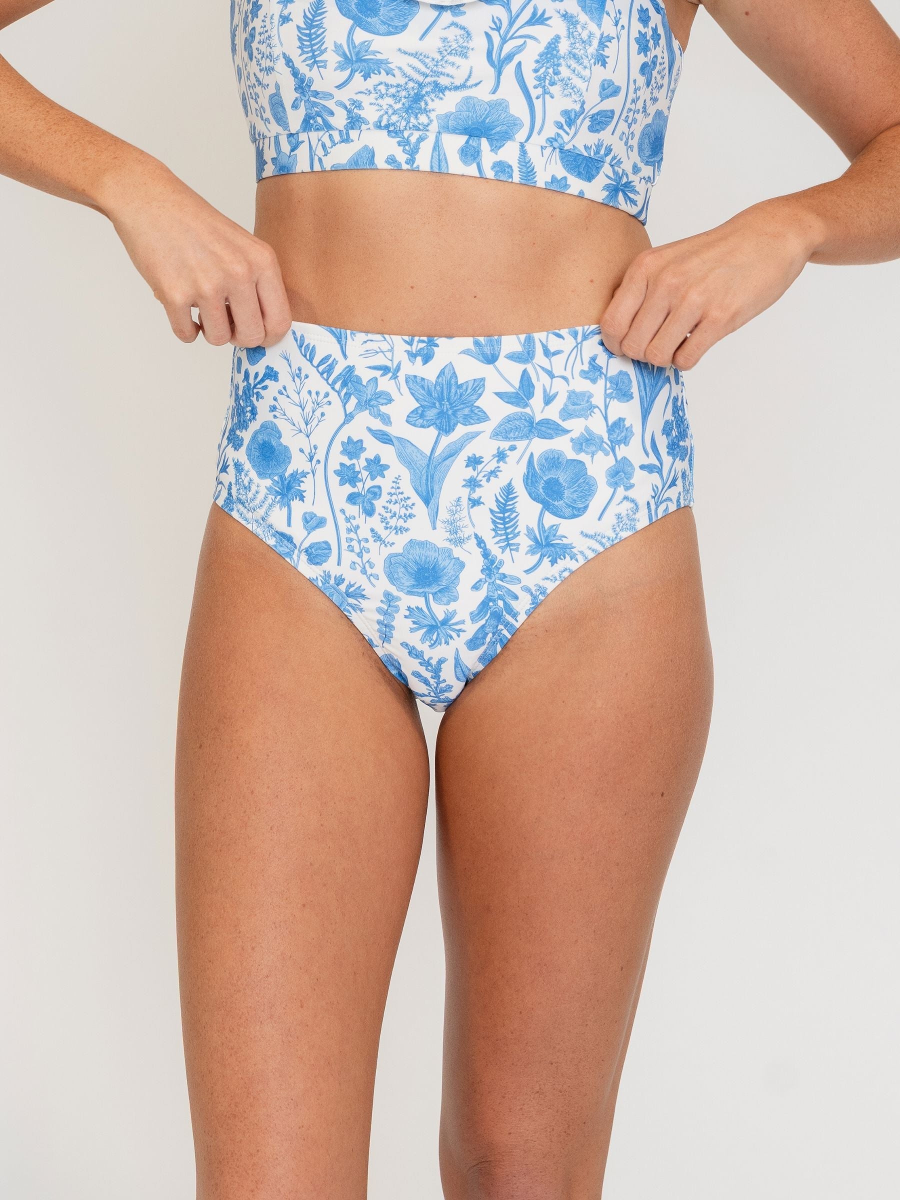 Woman wearing a blue floral bikini on a white background