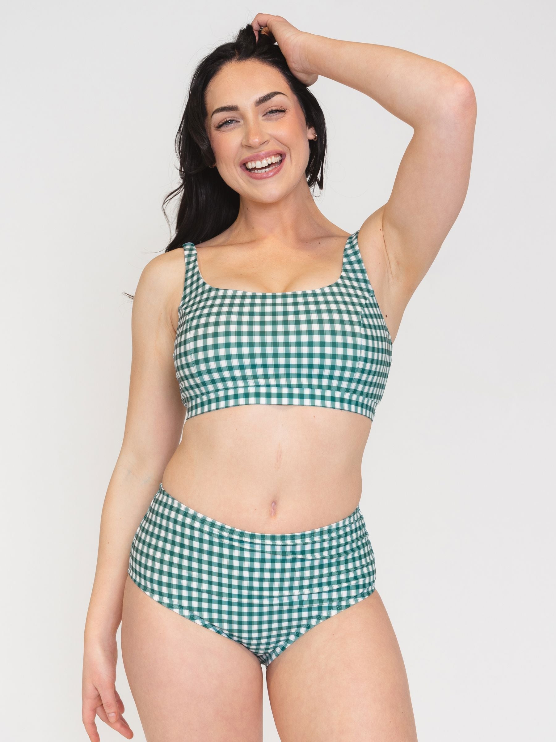 Woman wearing a green and white checkered bikini set on a white background