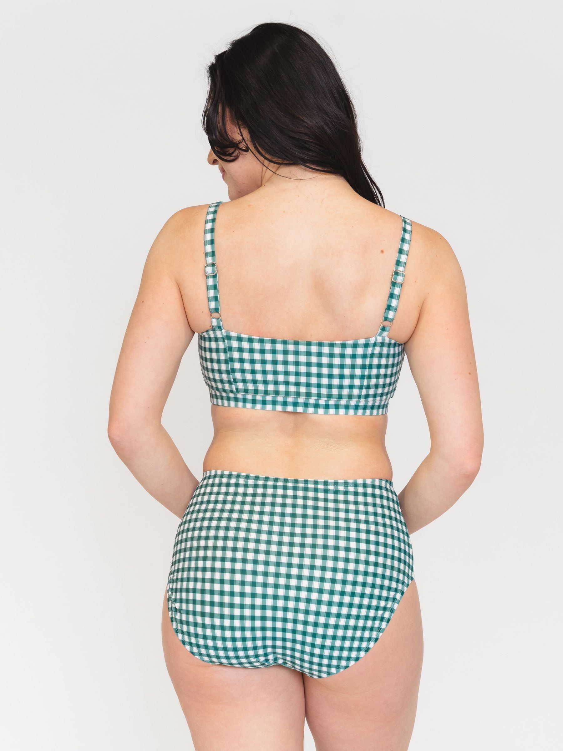 Back view of a Woman wearing a green checkered bikini set on a white background