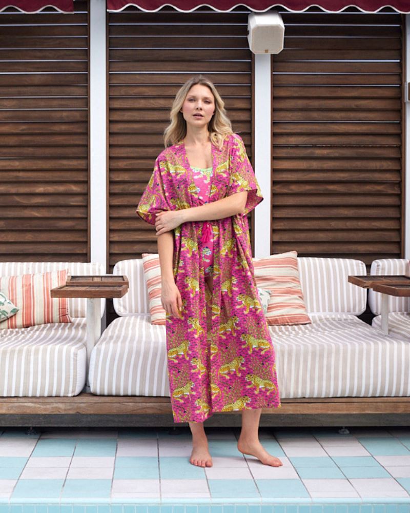 Photo of a woman wearing a bold pink and green print featuring tigers classic one-piece swim suit and a bold pink print featuring tigers swim suit cover-up