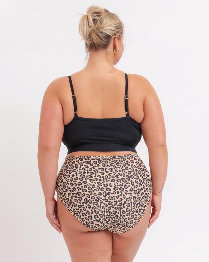 woman in a Black Sports Bra and a Leopard Bikini on a white background. View from Behind 