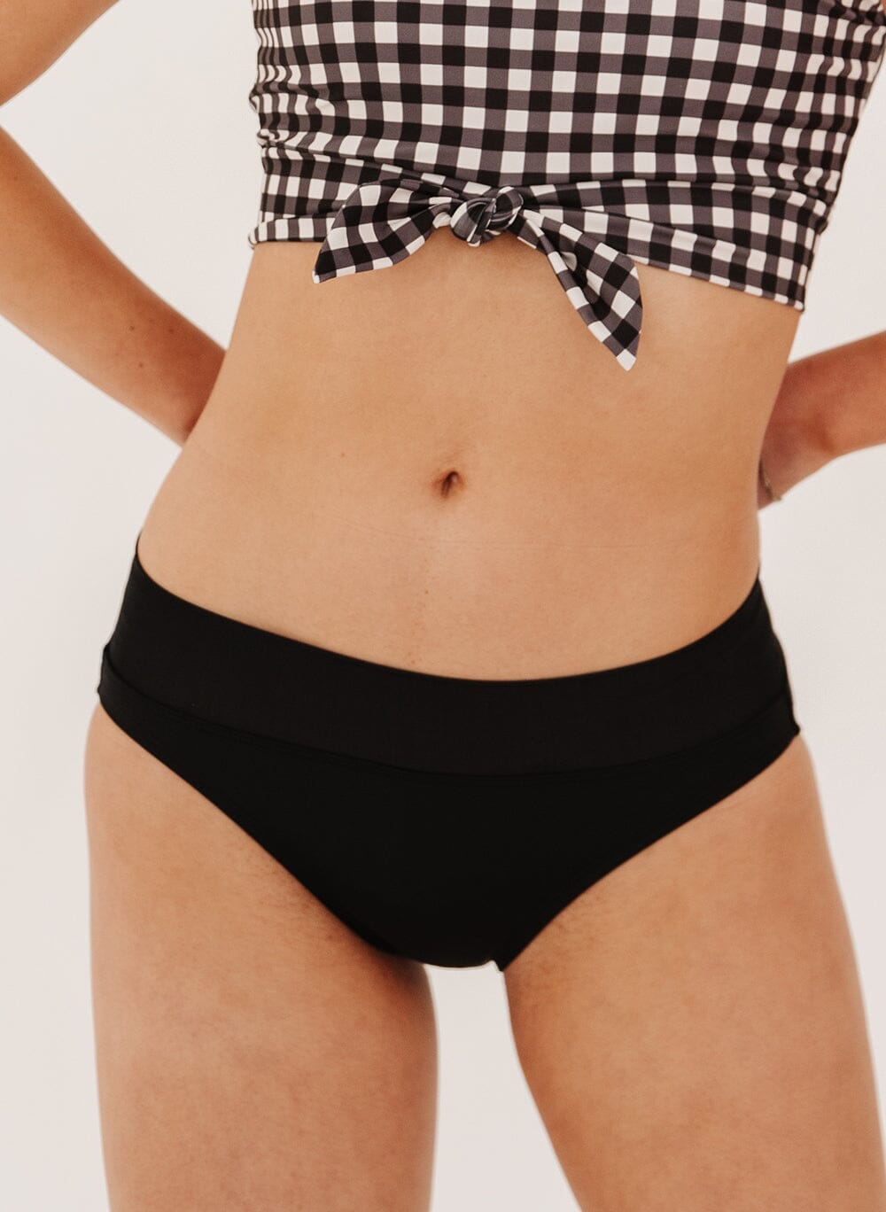 close up Photo of a woman in black classic black swim bottoms 