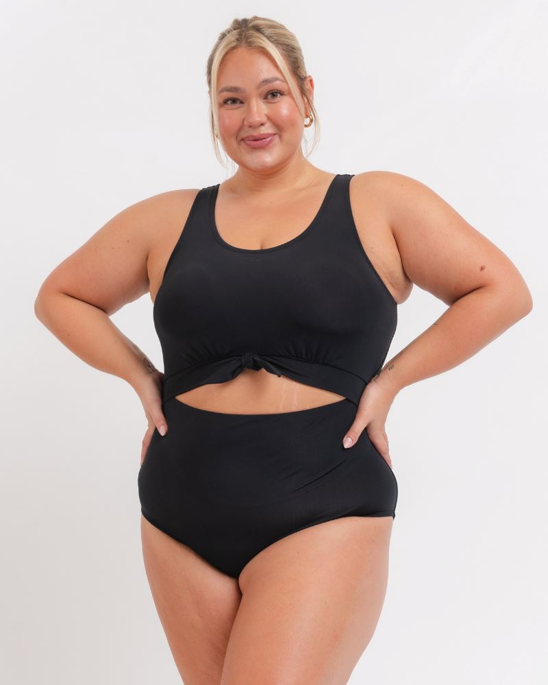 woman wearing a black knotted one piece  with a white background