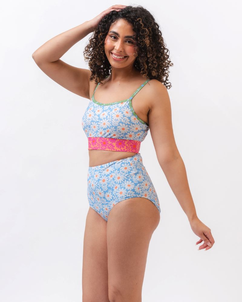 Photo of a woman wearing a blue and pink floral cropped swim top with blue floral high waist swim bottoms
