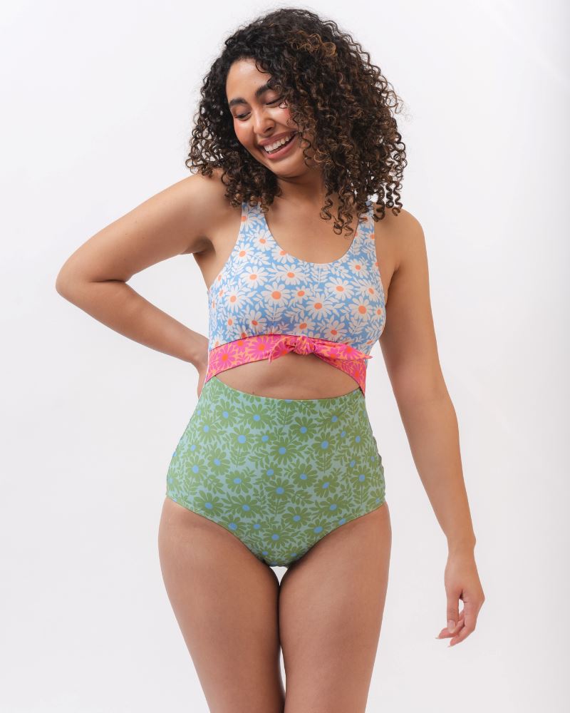 Photo of a woman wearing a blue and green floral knotted one piece swim suit