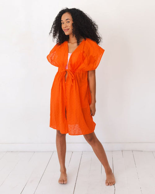 Photo of a woman wearing an orange Kaftan cover up
