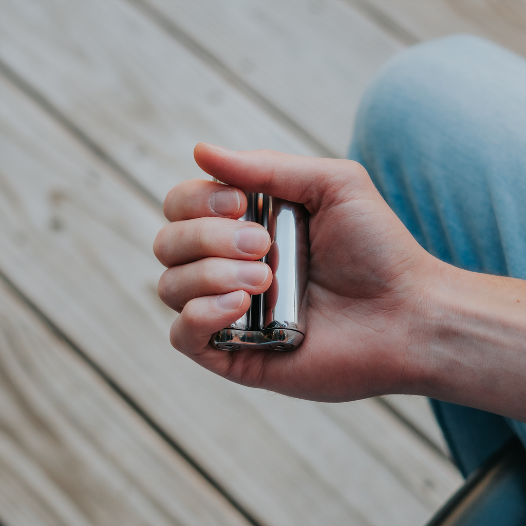 eam_Full | Hand holding ONO Roller Steel heavy weighted fidget toy on wooden deck