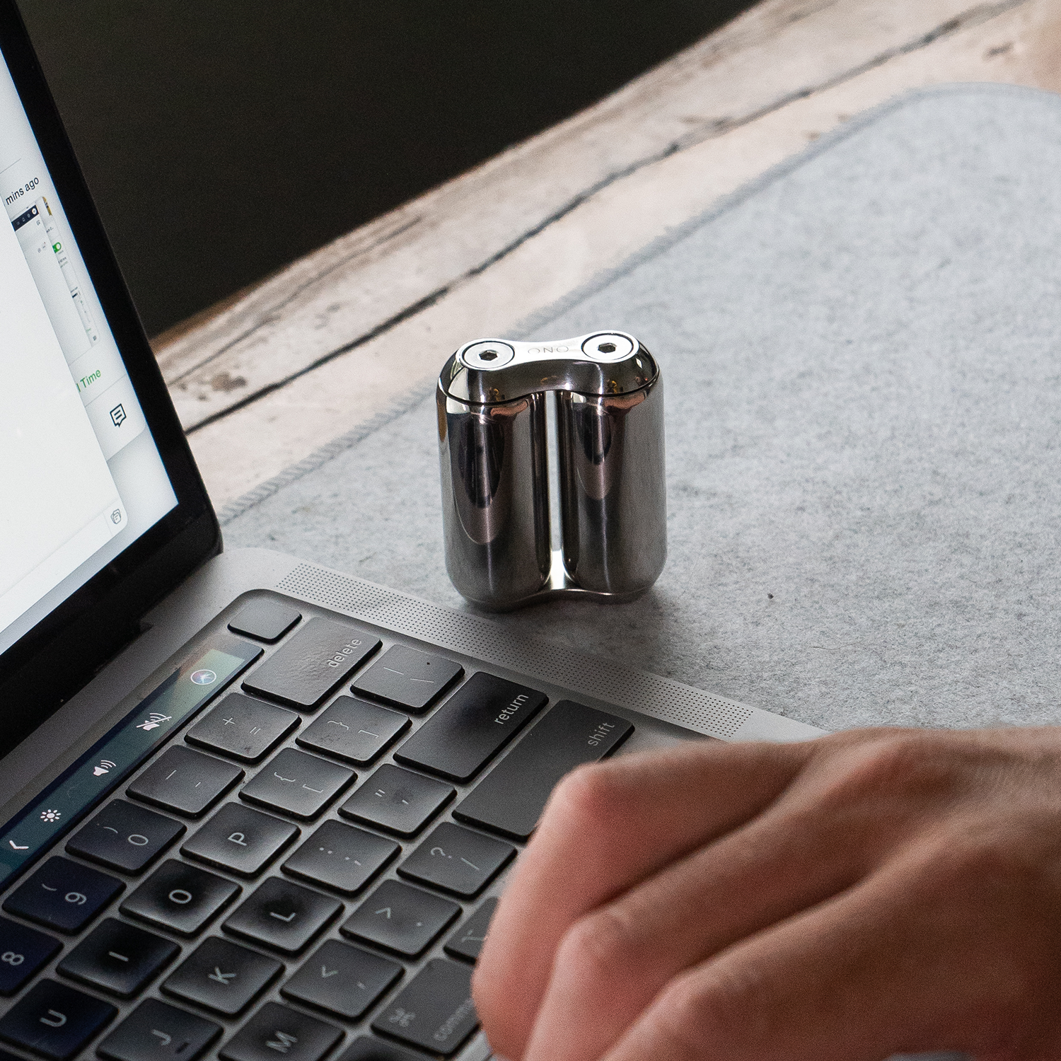 eam_Mini | ONO Roller Steel heavy weighted fidget toy on desk next to laptop keyboard