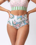 Close up photo of a woman wearing pink and white floral reversible high waist swim bottoms