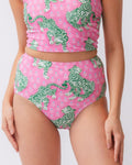 Close up photo of a woman wearing a bold pink and green tiger print high waist swim bottom